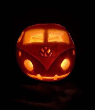 Pumpkin carved in shape of a camper van with candle inside