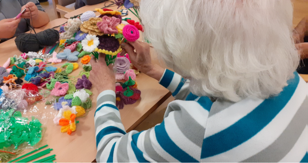 Patient at the Langworth Ward arranging knitted flowers